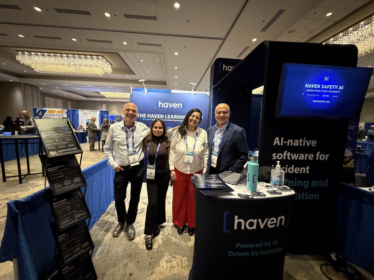 Colleagues smiling together at the Haven booth at a conference