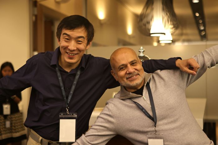 Two colleagues laughing together at an event