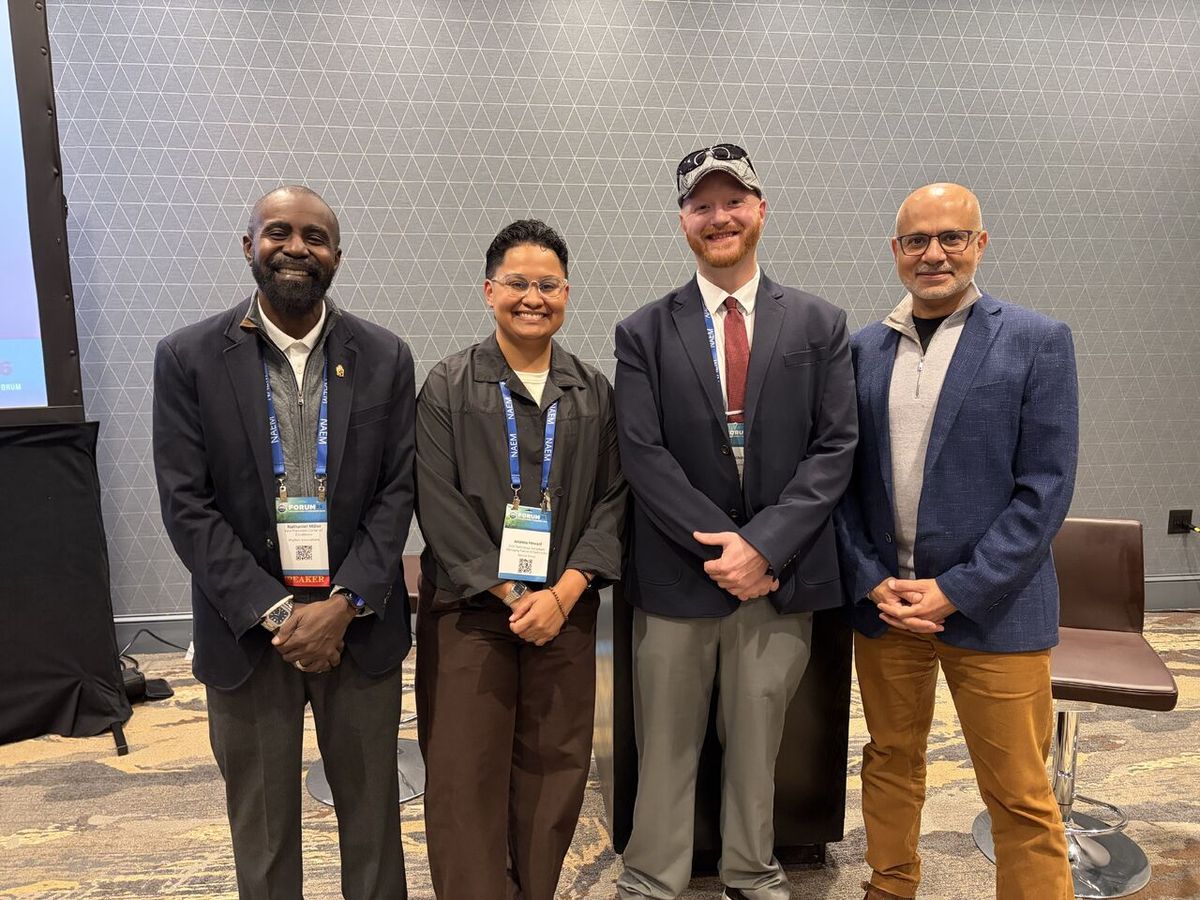 Four colleagues with conference badges standing together