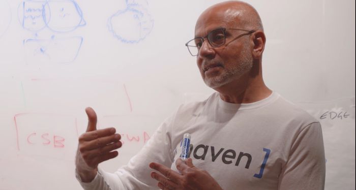 A colleague in a Haven shirt speaking and gesturing during a discussion
