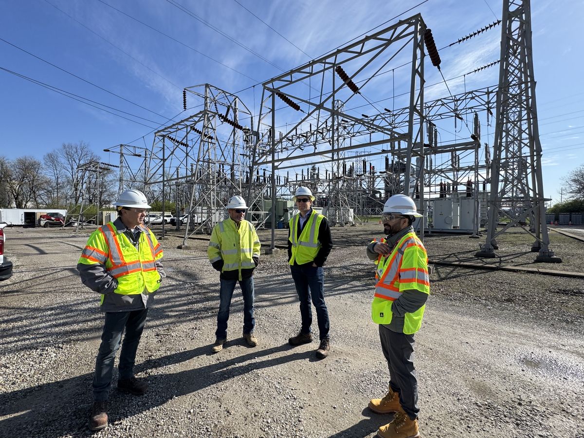 A group in hard hats and high-visibility vests during a visit to an electrical substation